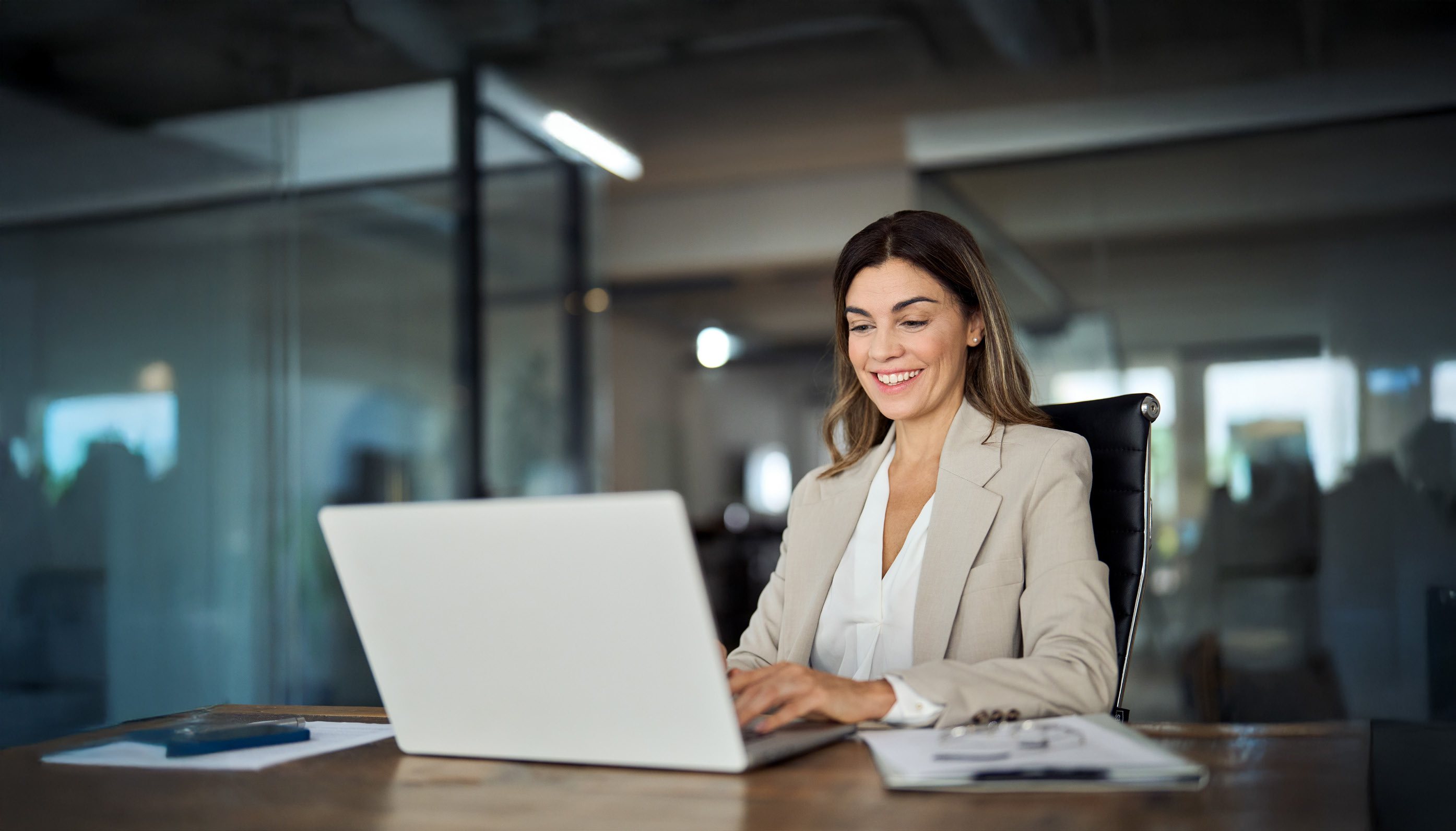 Profesional sonriendo mientras trabaja en su laptop